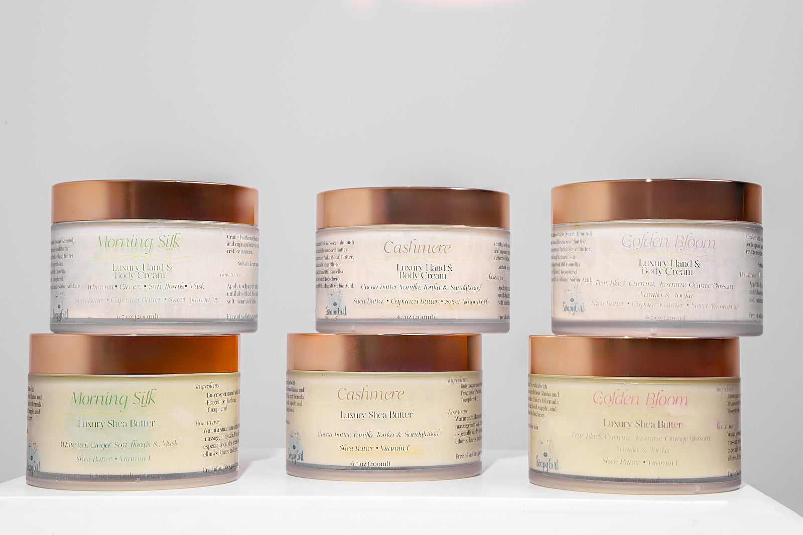 Three containers of a light-colored cream or balm on a white background