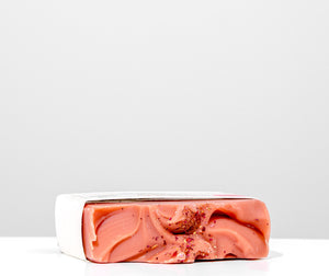 Pink soap bar with a marbled pattern on a white background