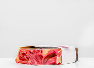 Colorful soap bar with pink, orange, and white swirls on a white background